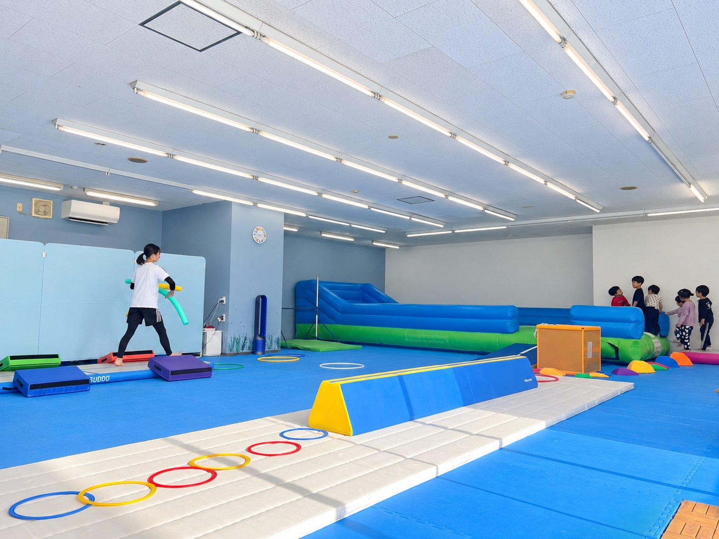 広い教室でさまざまな運動に取り組む子どもたち