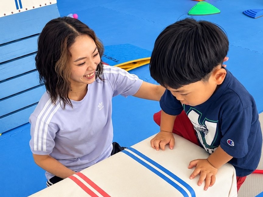 跳び箱にチャレンジする子どもと見守る指導員